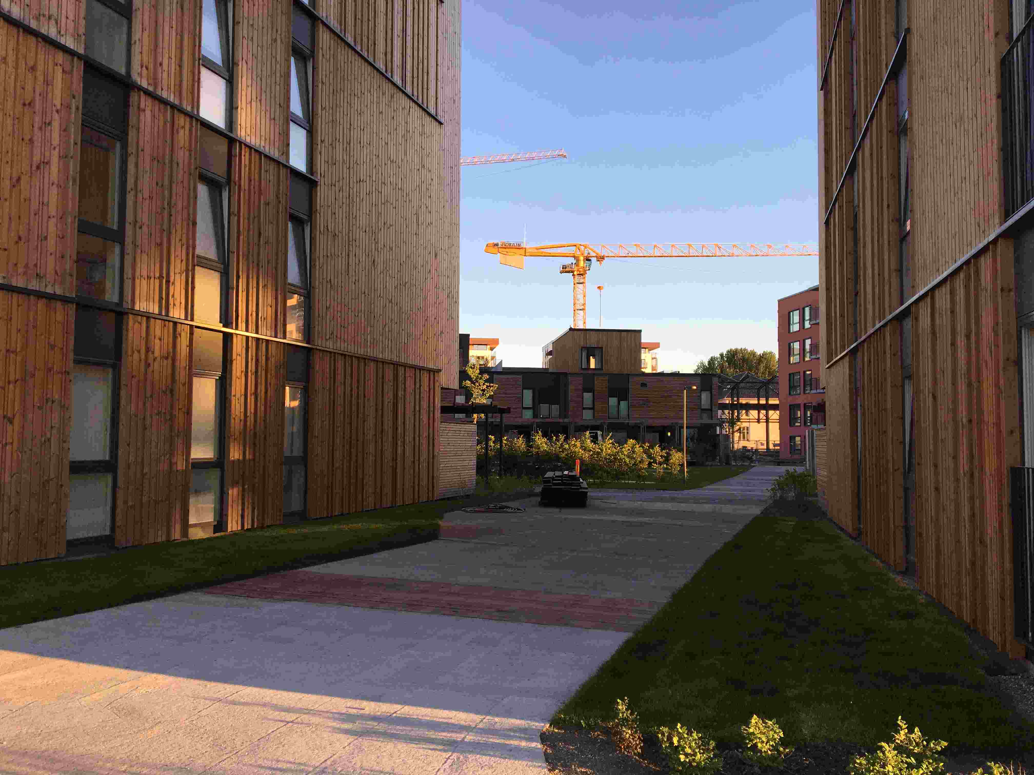 Bilde som er tatt mellom to bygg på Lilleby med en byggekran i horisonten